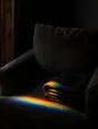 Refracted-light photograph: a deep armchair with a folded blanket, a band of refracted light resting on the seat.