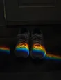 Refracted-light photograph: running shoes tied and ready by the front door in pre-dawn dark, crossed by a band of refracted light.