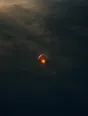 Dawn aerial photograph: a hot-air balloon glowing over a dark misty field at dawn.