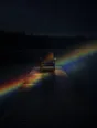 Refracted-light photograph: one chair at the end of a dock at night, refracted light crossing the boards and the lake.