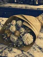 Banknote-style engraving: a kraft-wrapped bouquet lying on a marble kitchen counter in morning light.