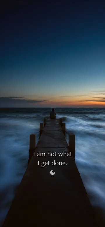 Affirmations for men wallpaper: long-exposure photograph of a man sitting alone at the end of a long pier at dusk, the sea running to silk around the pilings under a wide clear sky, with the affirmation 'I am not what I get done.' in serif type.