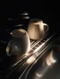 Prism-light photograph: Two mugs upturned on a wire drying rack beside a sink, one still wet, hard sun combing spectrum off the wires.