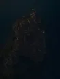 Dawn aerial photograph: a coastal town still asleep before dawn, one window lit at its edge.
