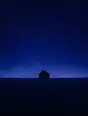 Grainy gradient illustration: A small dark house alone on a wide plain under a vast starry indigo sky, not one light on.