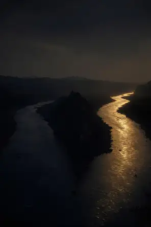 Dark elemental photograph: a river splitting around black rock at dusk, only one branch lit gold, its farthest bend dissolving into glowing marks.