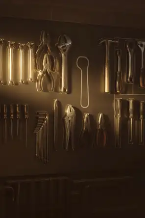 Struck-light photograph: a workshop wall of hand tools hung in painted outlines, one outline empty, low light rimming every steel edge