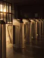 Struck-light photograph: turnstiles standing unlocked and open in a wide empty concourse at dawn