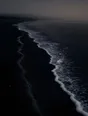 Dark elemental photograph: two foam tide lines on black sand at grey dawn, the fresh higher line still forming as faint silver marks.
