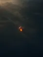 Dawn aerial photograph: a hot-air balloon glowing over a dark misty field at dawn.