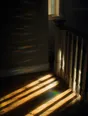 Prism-light photograph: A stair landing at the top of a flight, morning sun raking across the banister spindles and the floorboards.