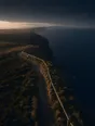 Dawn aerial photograph: a clifftop path with a wooden handrail along its seaward edge, sea dark below.
