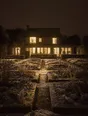 Struck-light photograph: a still winter garden at first light, everything cut back, the house behind it warm and lit