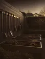 Struck-light photograph: a garden at dusk cut back for winter, beds squared off, tools hung and put away along the wall