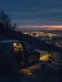 Dark cinematic photograph: A car parked on a verge at dusk with its interior light on, the lights of a town spread out below.