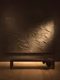Struck-light photograph: one very large dark canvas alone on a gallery wall, its thick paint bouncing light onto the bench below
