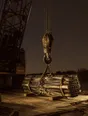 Struck-light photograph: a crane hook coming down onto a lit dock at dusk with the load already waiting beneath it