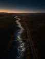 Dawn aerial photograph: a whitewater river running beside a calm towpath with a small footbridge.