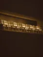 Struck-light photograph: a private box above a dark arena at night with one row of seats lit and the bowl below black