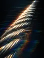 Prism-light photograph: A suspension bridge cable seen close in, its wound steel strands combing hard sun into spectrum.