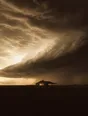 Struck-light photograph: a huge storm front crossing a dark plain at dusk with one lit farmhouse holding under it