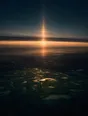 Dawn aerial photograph: a vertical pillar of sunrise light rising from the horizon over plain fields.