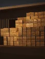 Struck-light photograph: full crates stacked high outside a modern packhouse at dusk, low light raking the face of the stack