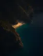 Dawn aerial photograph: a tiny pocket beach between dark headlands catching the first gold light.