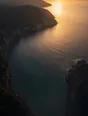 Dawn aerial photograph: a wide east-facing cove open to the sunrise, calm without a harbor wall.
