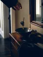 Dark cinematic photograph: A set of keys dropping into a bowl on a hall table in warm light, a hand just leaving frame.
