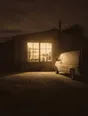 Struck-light photograph: a converted workshop lived in as a home at night, one big window lit, a van parked outside