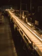 Struck-light photograph: a night shift running in a modern plant with one production line lit from end to end