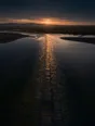 Dawn aerial photograph: an old paved ford crossing straight through a shallow gold-lit river.