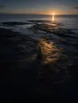 Dawn aerial photograph: a carefully balanced stack of stones on smooth shore rocks at sunrise.