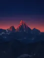 Film photograph: the highest peak catching the first pink light of dawn while every other summit is still dark blue.