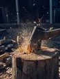 Motion photograph: an axe caught mid-swing into a block in a yard at midday, split chips flying