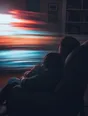 Motion photograph: a man asleep in a chair at night with a child asleep against him, both dark against the screen's moving light